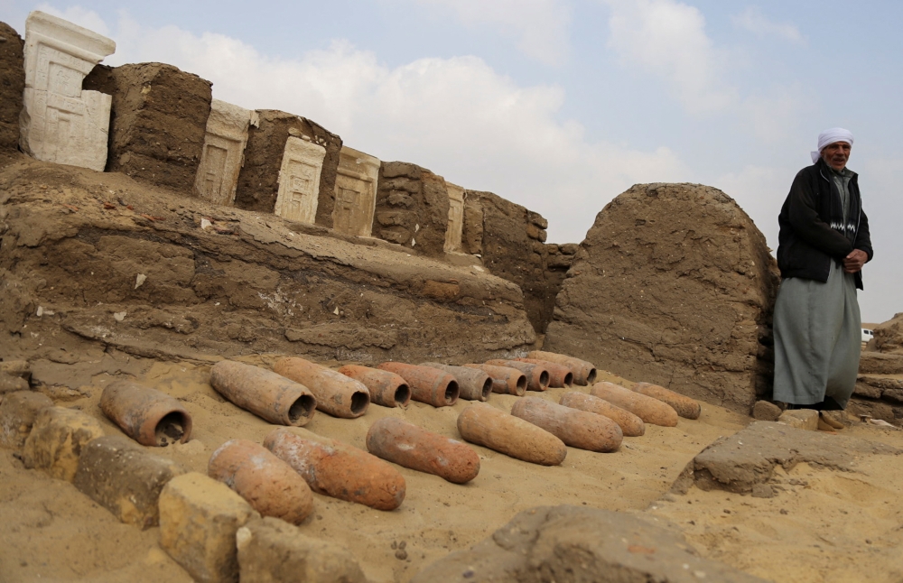 An archaeologist looks on after working outside a newly discovered tombs at the Saqqara area, in Giza, Egypt, March 19, 2022. REUTERS/Hanaa Habib