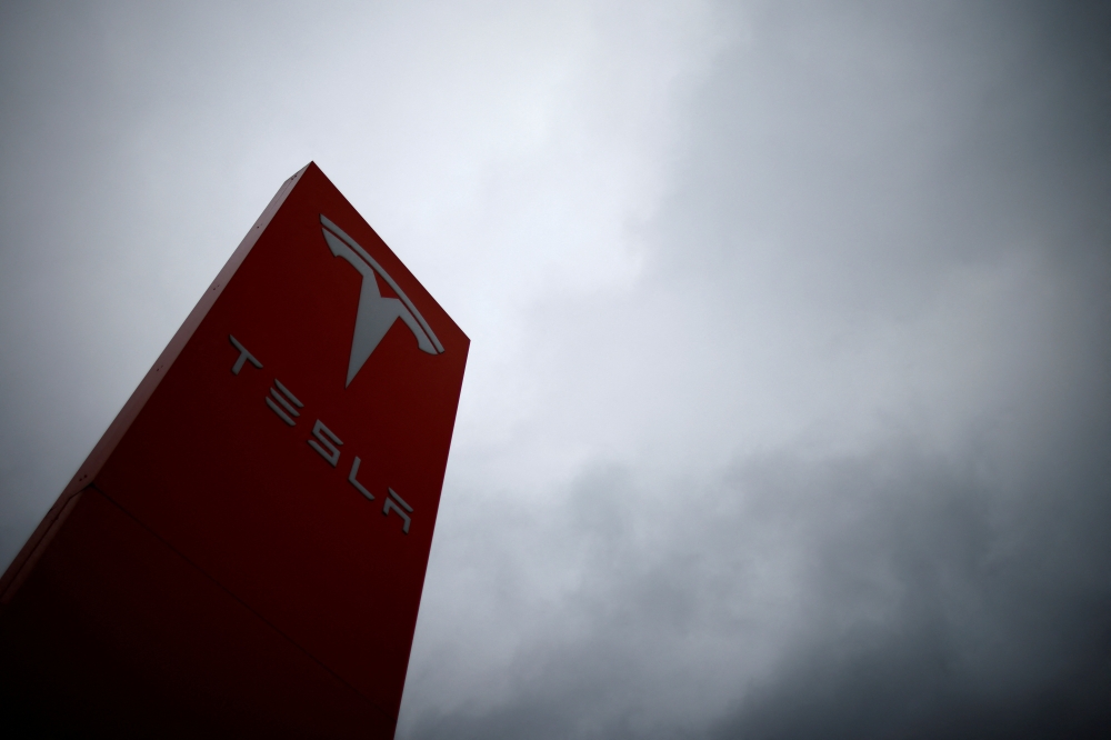 FILE PHOTO: The logo of Tesla is pictured at a dealership in Chambourcy, near Paris, France, December 15, 2021. REUTERS/Gonzalo Fuentes