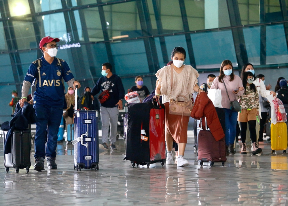 Visitors walk after they arrived at the Soekarno-Hatta Airport following Indonesia's government decision to ban foreign tourists from entry to prevent the spread of coronavirus disease (COVID-19), in Tangerang, on the outskirts of Jakarta, Indonesia, January 1, 2021. REUTERS/Ajeng Dinar Ulfiana/File Photo