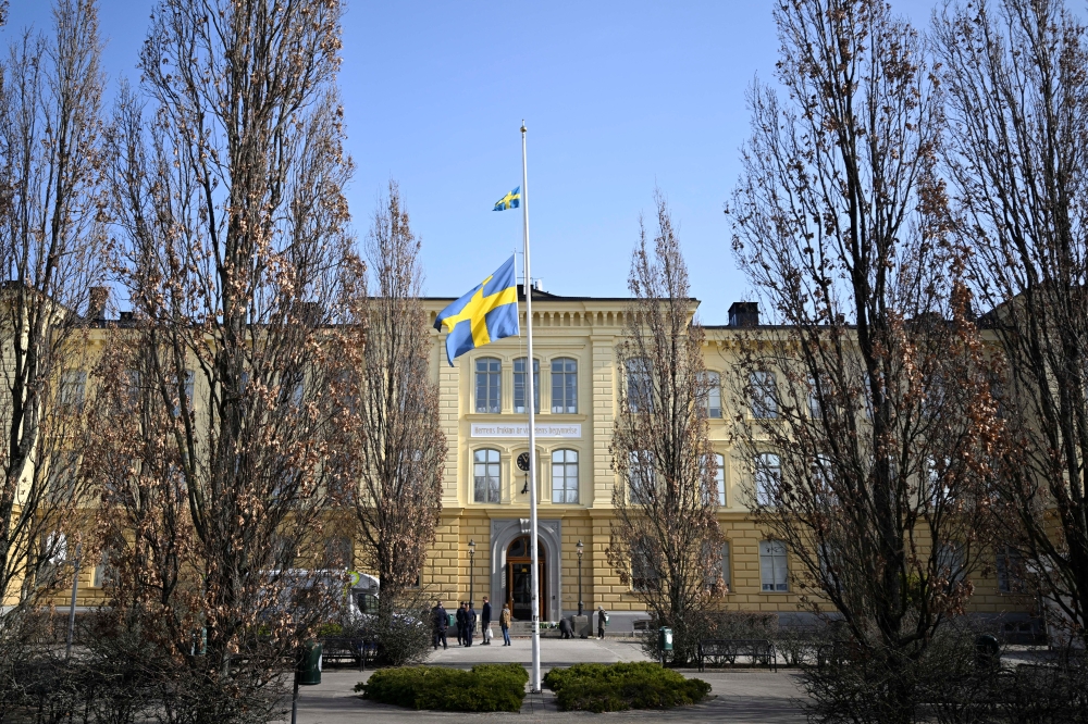 Swedish flag is seen at half mast outside Malmo Latin School, the day after two women died from 