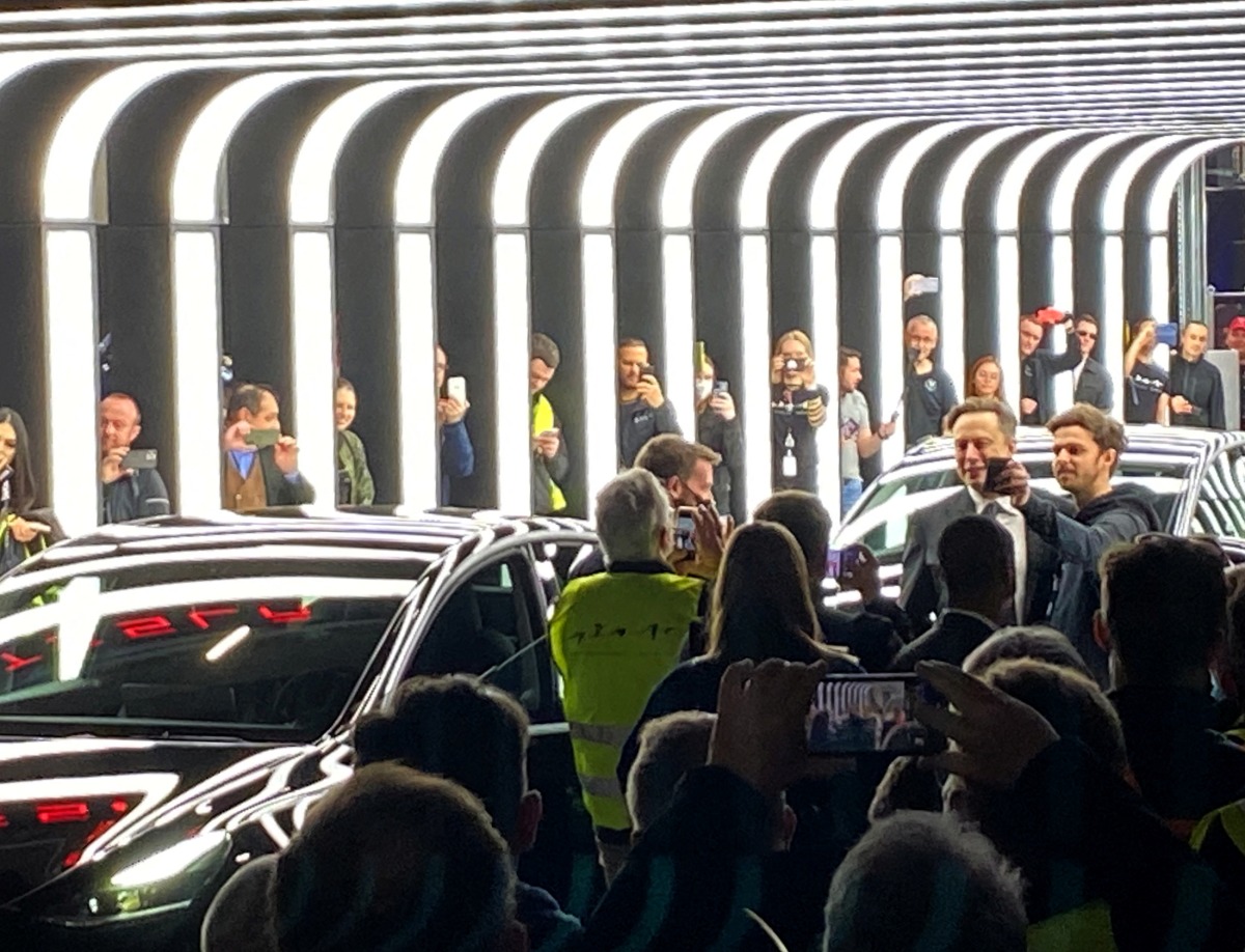 People take pictures of Elon Musk during a delivery ceremony inside the new Tesla Gigafactory for electric cars in Gruenheide, Germany, March 22, 2022. REUTERS/Nadine Schimroszik
