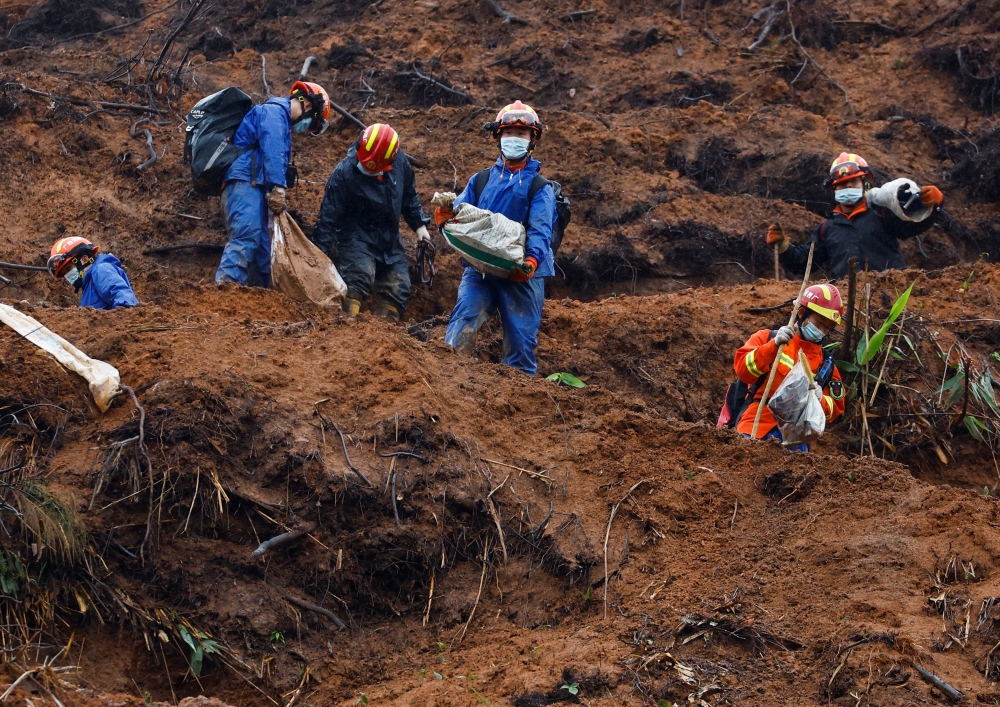 Rescue workers work at the site where a China Eastern Airlines Boeing 737-800 plane flying from Kunming to Guangzhou crashed, in Wuzhou, Guangxi Zhuang Autonomous Region, China March 24, 2022. REUTERS/Carlos Garcia Rawlins