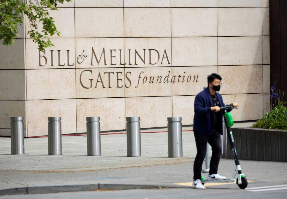 A person passes by on a scooter in front of the Bill & Melinda Gates Foundation in Seattle, Washington, U.S. May 5, 2021. REUTERS/Lindsey Wasson/File Photo