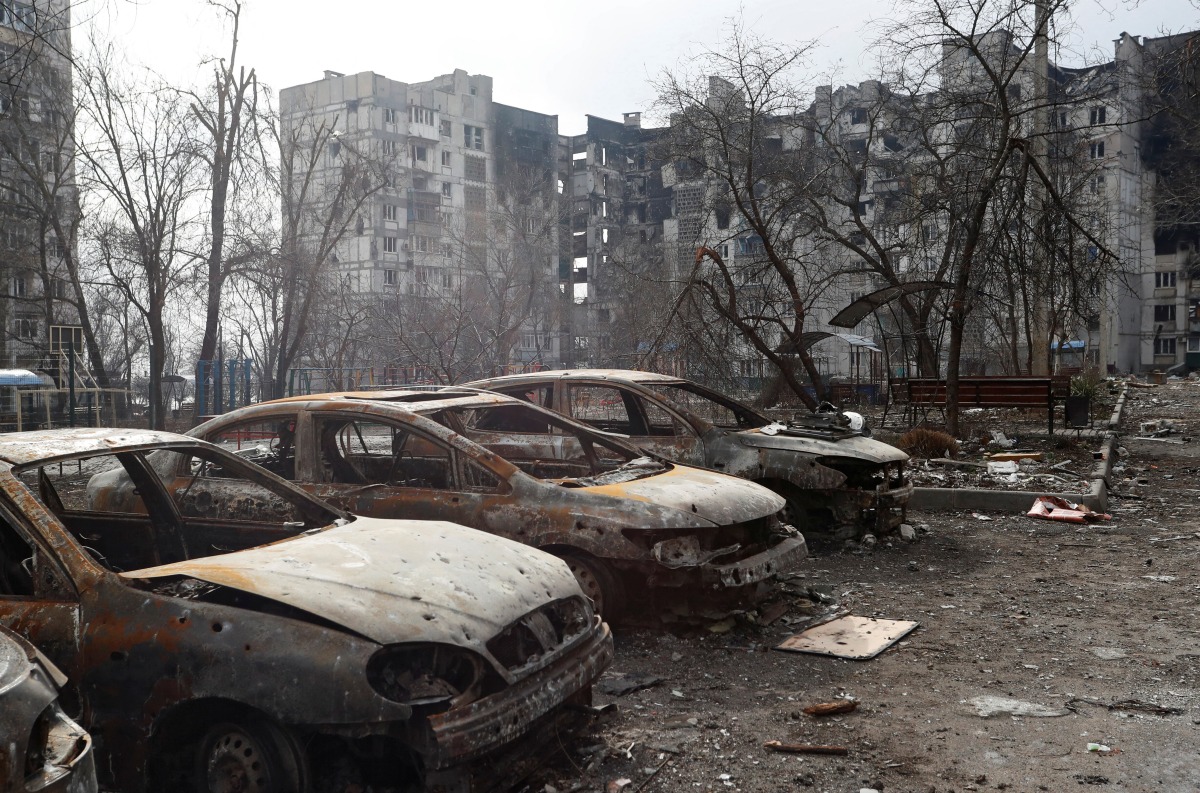 Charred cars are seen in front of an apartment building which was heavily damaged during Ukraine-Russia conflict in the besieged southern port city of Mariupol, Ukraine March 27, 2022. REUTERS/Alexander Ermochenko
