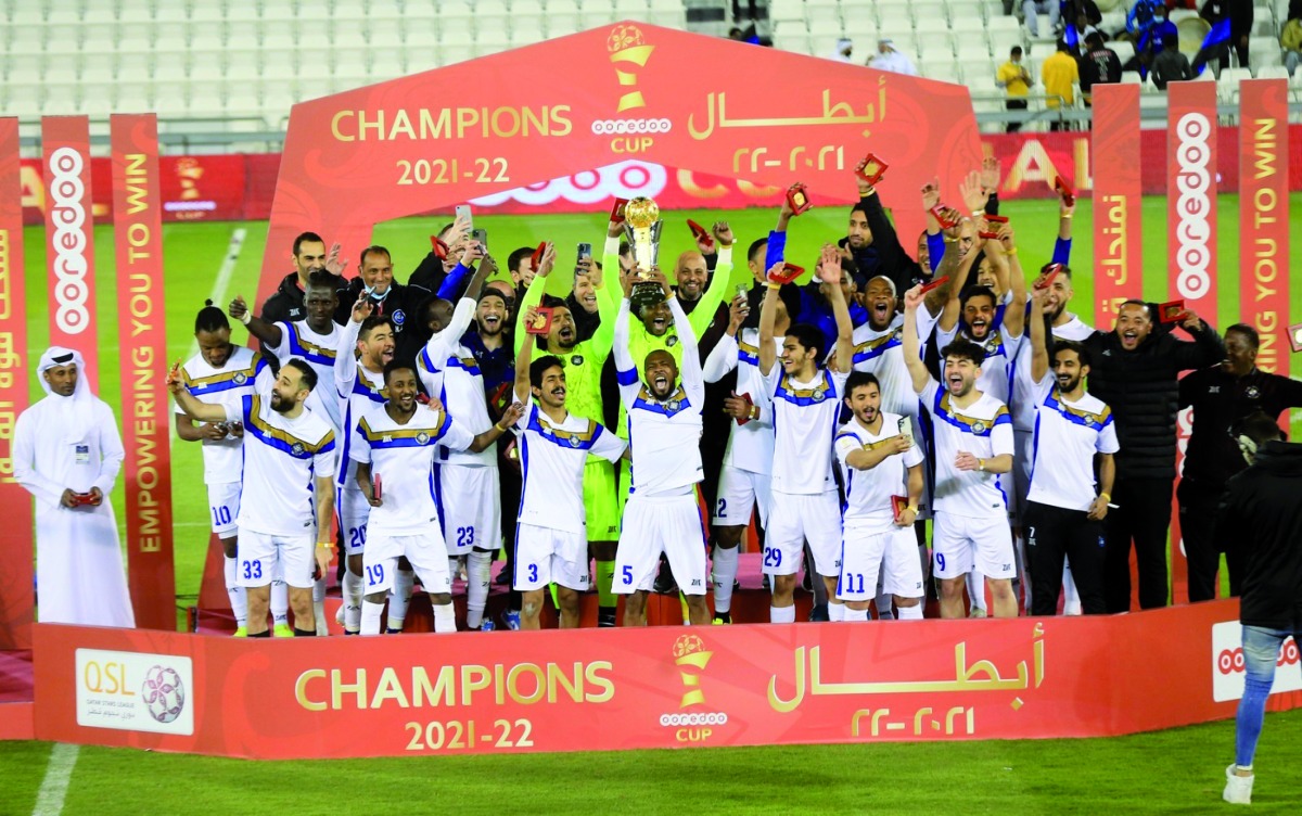 Al Sailiya's players and officials celebrate with the trophy after winning the final.