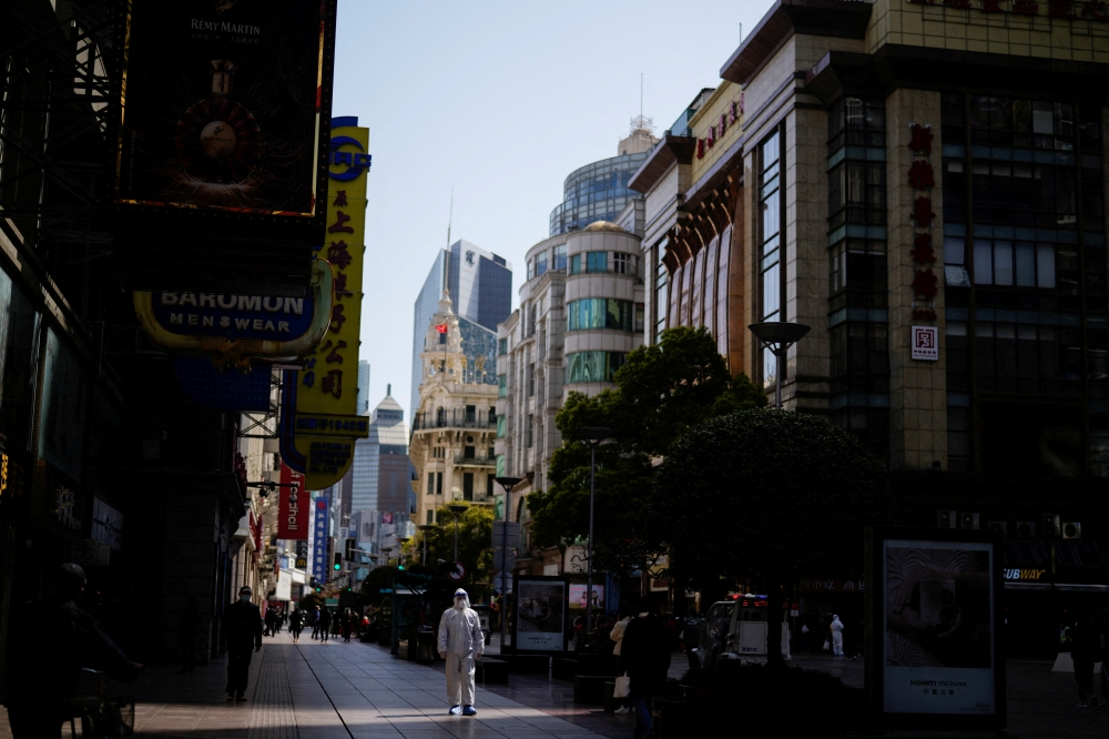 A security guard in personal protective equipment (PPE) walks at a main shopping area following the coronavirus disease (COVID-19) outbreak in Shanghai, China March 29, 2022. REUTERS/Aly Song