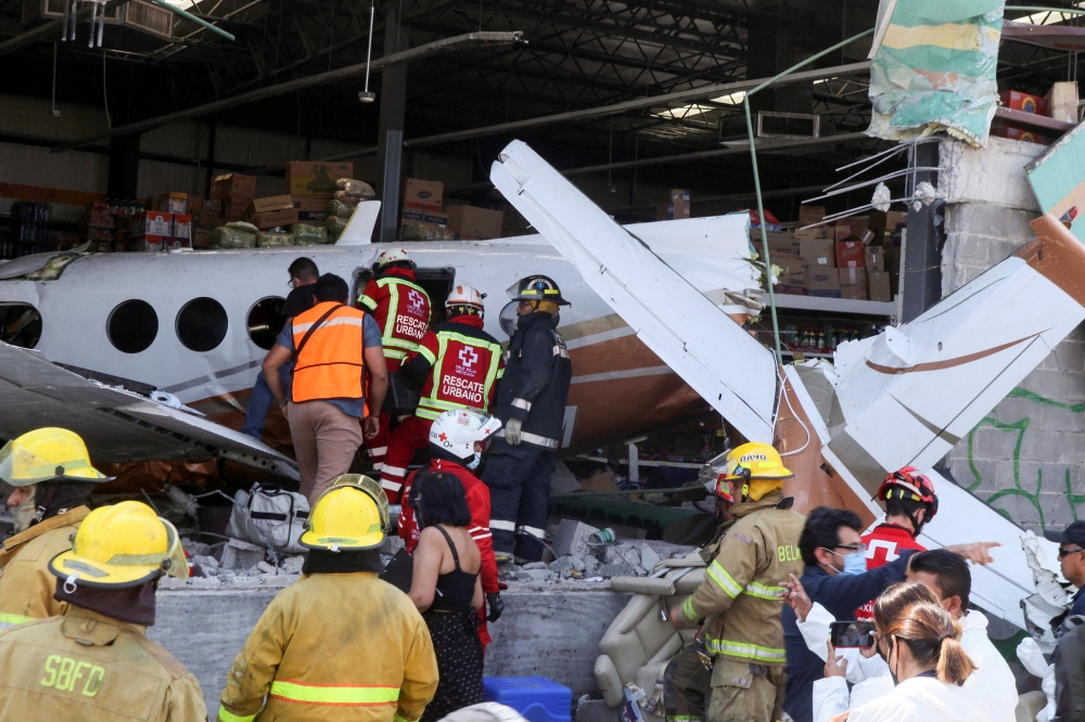 Rescue personnel inspect the wreckage of a small plane that crashed into a supermarket, in Temixco, in Morelos state, Mexico March 28, 2022. REUTERS/Margarito Perez