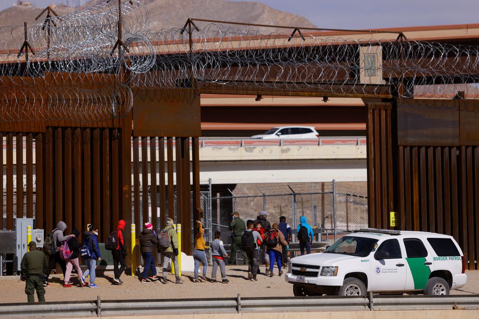 Migrants are detained by U.S. Border Patrol agents after crossing the Rio Bravo river to turn themselves in to request for asylum in El Paso, Texas, U.S., as seen from Ciudad Juarez, Mexico, February 24, 2022. REUTERS/Jose Luis Gonzalez


