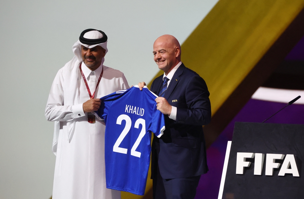 Prime Minister HE Sheikh Khalid bin Khalifa bin Abdulaziz Al Thani receives FIFA T-shirt from FIFA president HE Gianni Infantino during the FIFA Congress