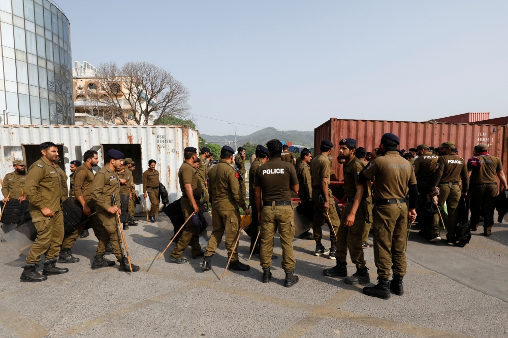 Police officers guard a street where shipping containers have been used to block the road leading towards the Red Zone and parliament building, in Islamabad, Pakistan April 3, 2022. Reuters/Akhtar Soomro