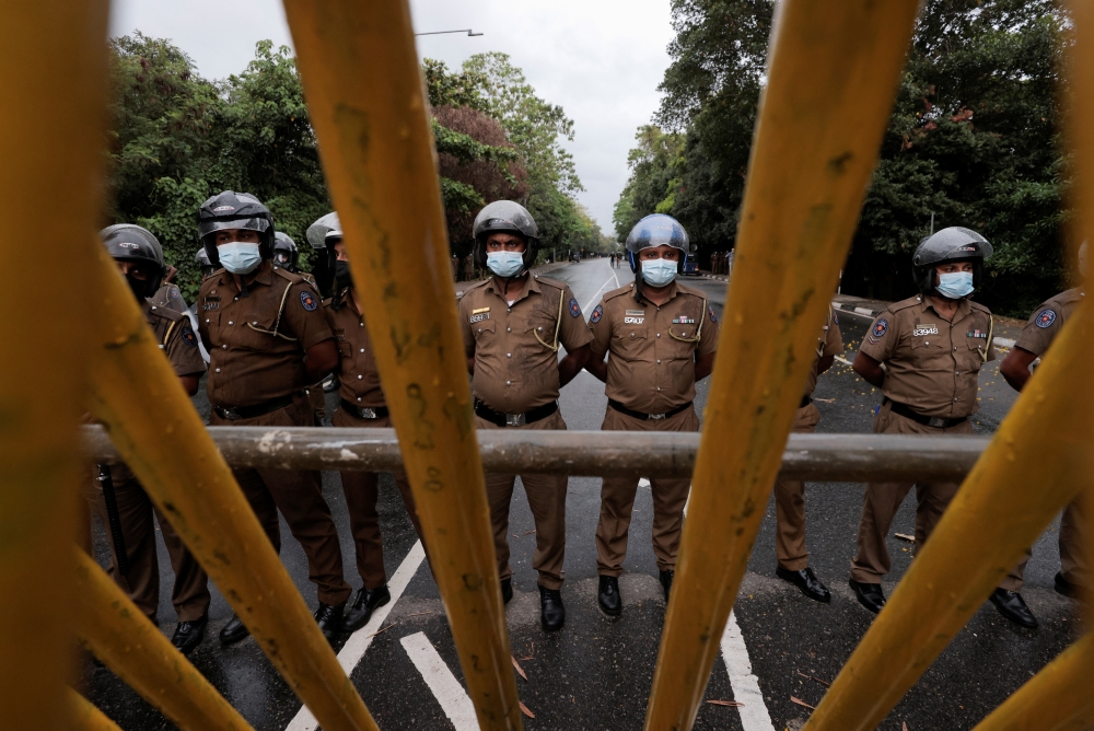 Sri Lanka police officers stand guard on a road leading to the parliament building, after the government of President Gotabaya Rajapaksa lost its majority, amid the country's economic crisis, in Colombo, Sri Lanka, April 5, 2022. REUTERS/Dinuka Liyanawatte