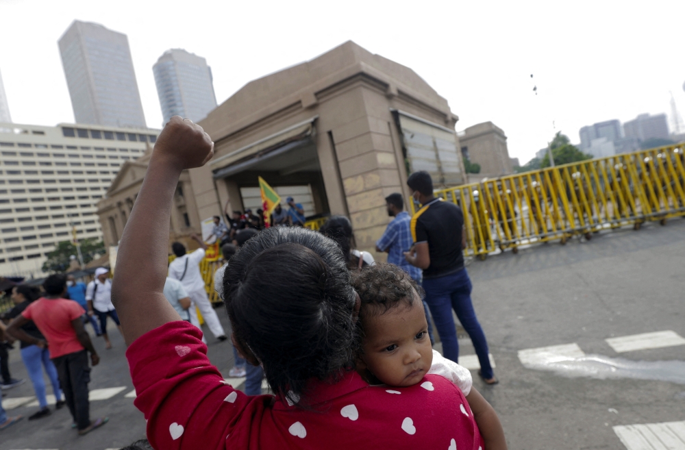 A woman carries her baby and shouts slogans on the fourth consecutive day of protests against Sri Lankan President Gotabaya Rajapaksa in front of the Presidential Secretariat, amid the country's economic crisis, in Colombo, Sri Lanka, April 12, 2022. REUTERS/Dinuka Liyanawatte