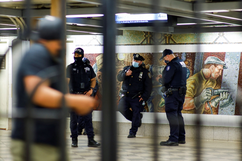 New York Police officers stand guard inside the 36th St. subway station, a day after a shooting incident took place in the Brooklyn borough of New York City, U.S., April 13, 2022. REUTERS/Eduardo Munoz

