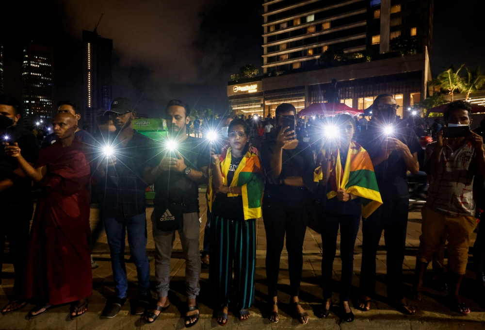 Demonstrators flash flashlights during a candlelight vigil after Sri Lankan police fired live ammunition, in Colombo, Sri Lanka, April 19, 2022. Reuters/Navesh Chitrakar