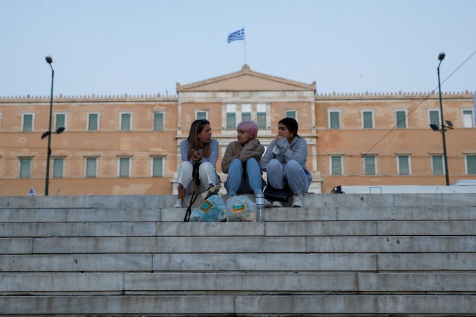 People sit at Syntagma square where the parliament building is seen in the background, in Athens, Greece April 20, 2022. REUTERS/Costas Baltas


