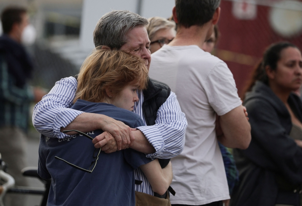 Family members hug and react emotionally as they wait at the family reunification center at the Cleveland Park Library for schoolchildren to be brought to the center after a shooting and active shooter near Edmund Burke Middle School in the Cleveland Park neighborhood of Northwest Washington, U.S., April 22, 2022. Reuters/Evelyn Hockstein