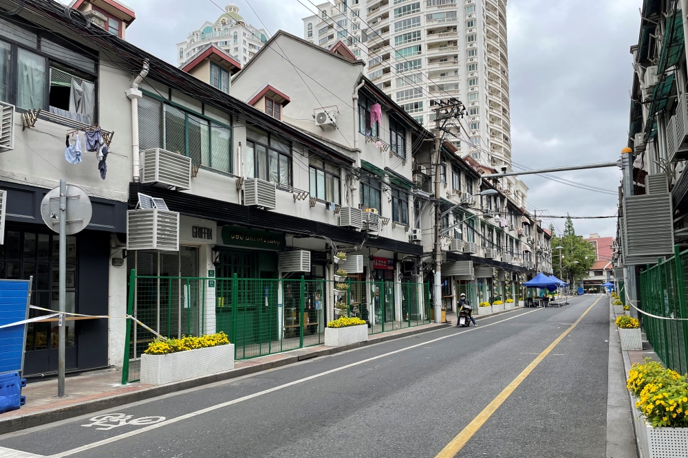 Green fences seal entrances to shops and housing units along a street, amid the coronavirus disease (COVID-19) outbreak in Shanghai, China April 24, 2022. Reuters/Jacqueline Wong