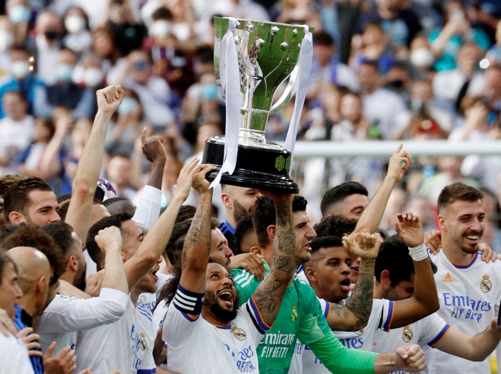 Real Madrid's Marcelo holds the trophy and celebrates with team members after winning LaLiga REUTERS/Susana Vera
