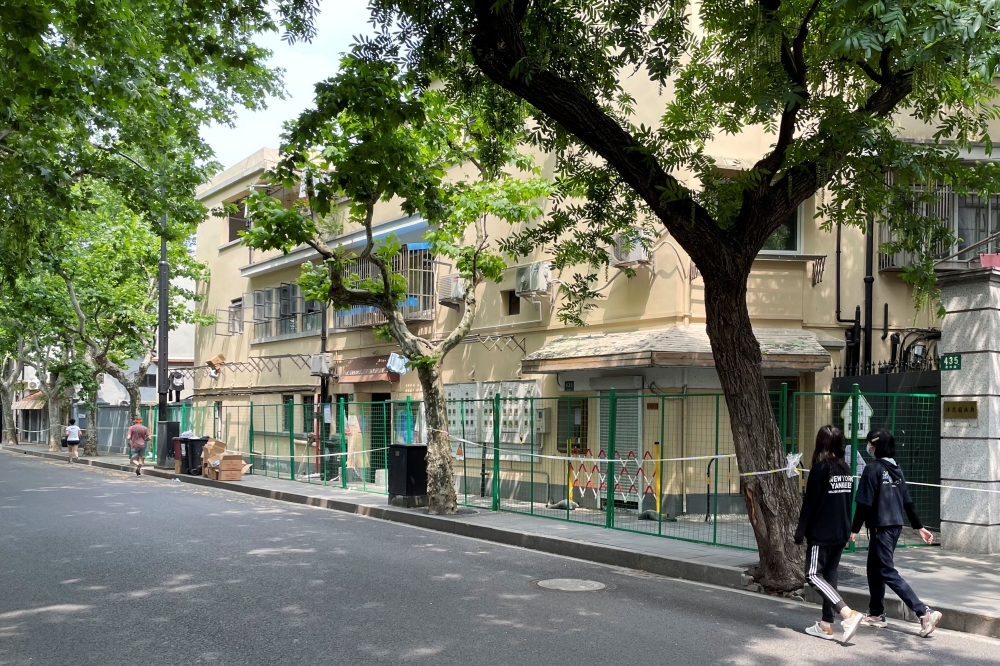 People walk past green fences and police cordons along Wukang Road amid the coronavirus disease (COVID-19) outbreak in Shanghai, China May 2, 2022. Reuters/Jacqueline Wong