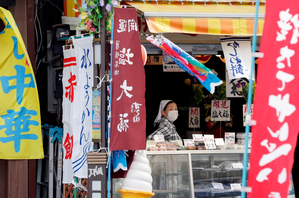 A woman wearing protective mask waits for customers at a market district in Tokyo, Japan May 13, 2020.REUTERS/Kim Kyung-Hoon/File Photo
