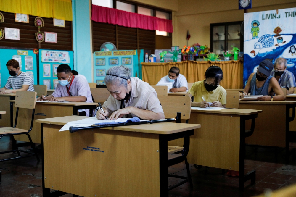 Filipinos cast their ballots at a polling precinct during the national elections in Manila, Philippines, May 9, 2022. REUTERS/Willy Kurniawan