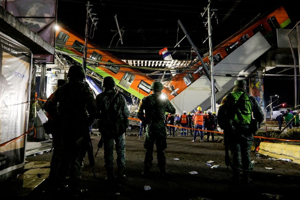 Soldiers stand as rescuers work at a site where an overpass for a metro partially collapsed with train cars on it at Olivos station in Mexico City, Mexico, May 4, 2021. REUTERS/Luis Cortes/File Photo

