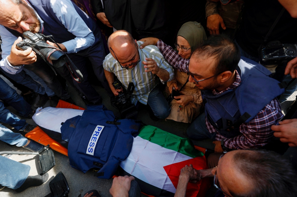 Mourners, including journalists, react next to the body of Al Jazeera reporter Shireen Abu Akleh, May 11, 2022. Reuters/Mohamad Torokman