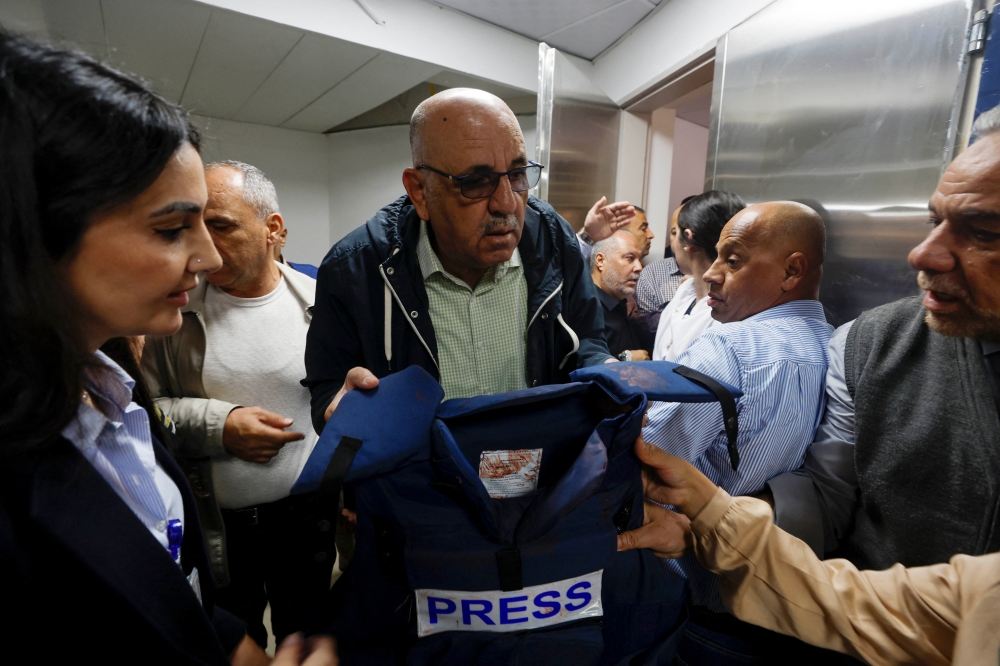 Walid Al-Omari, Al Jazeera's Palestine bureau Chief, holds the flak jacket that Al Jazeera reporter Shireen Abu Akleh was wearing when she was killed. (REUTERS/Mohamad Torokman)