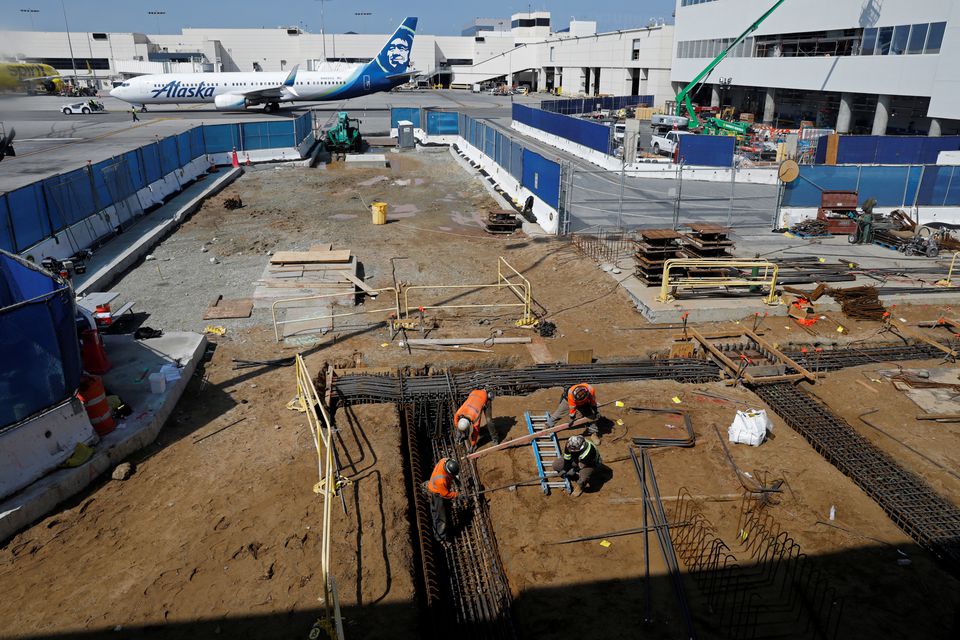 Workers prepare a cabling trench at a construction site at Los Angeles International Airport (LAX) in Los Angeles, California, U.S., March 30, 2022. Picture taken March 30, 2022. REUTERS/Chris Helgren/File Photo

