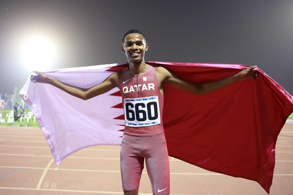 Abdul Rahman Hassan celebrates with the Qatari flag after winning men’s 800m race.