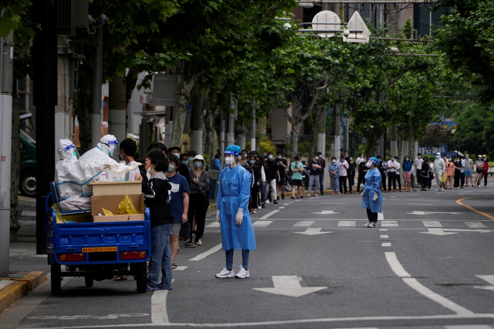 Residents line up for nucleic acid tests on a street during lockdown, amid the coronavirus disease (COVID-19) pandemic, in Shanghai, China, May 19, 2022. REUTERS/Aly Song
 