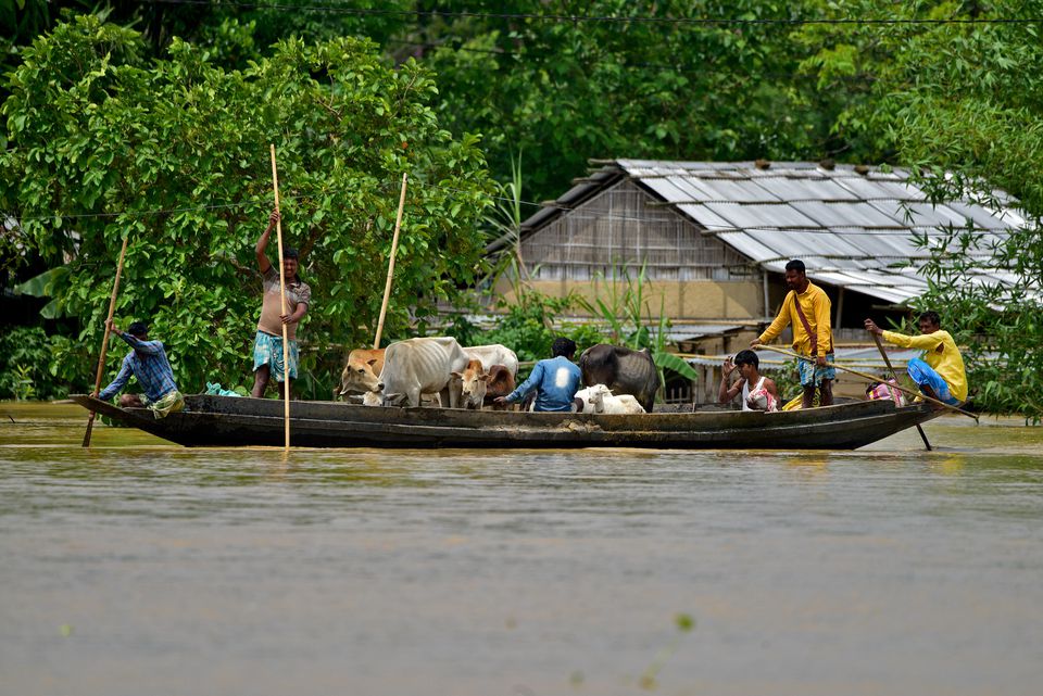 Flood-affected people ferry their cattle to safer places through a flooded field after heavy rains in Nagaon district, in the northeastern state of Assam, India May 19, 2022. REUTERS/Anuwar Hazarika


