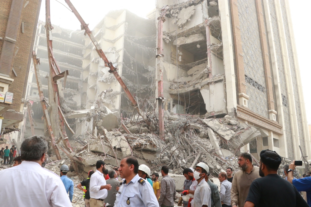 Iranians gather at the site of a ten-storey building collapse in Abadan, Iran May 23, 2022. WANA (West Asia News Agency) via REUTERS