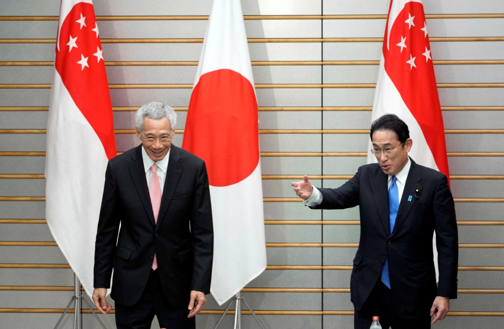 Japan’s Prime Minister Fumio Kishida invites Singapore's Prime Minister Lee Hsien Loong to take a seat at the start of their meeting at Kishida's official residence in Tokyo, Japan May 26, 2022. Franck Robichon/Pool via Reuters