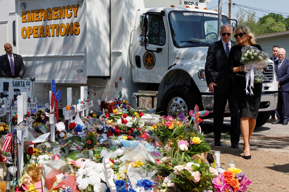 US President Joe Biden and first lady Jill Biden, who holds a bouquet of 21 white flowers, pay their respects at a memorial at Robb Elementary School, in Uvalde, Texas, U.S. May 29, 2022. Reuters/Jonathan Ernst