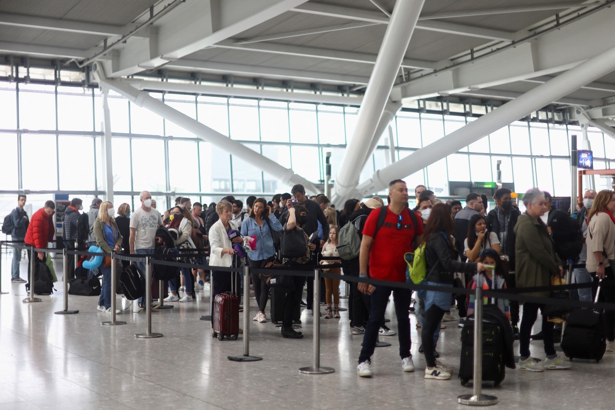 FILE PHOTO: Passengers queue to enter airport security ahead of the Easter Bank Holiday weekend, at Terminal 5 of Heathrow Airport, in London, Britain, April 14, 2022. REUTERS/Hannah McKay/File Photo
