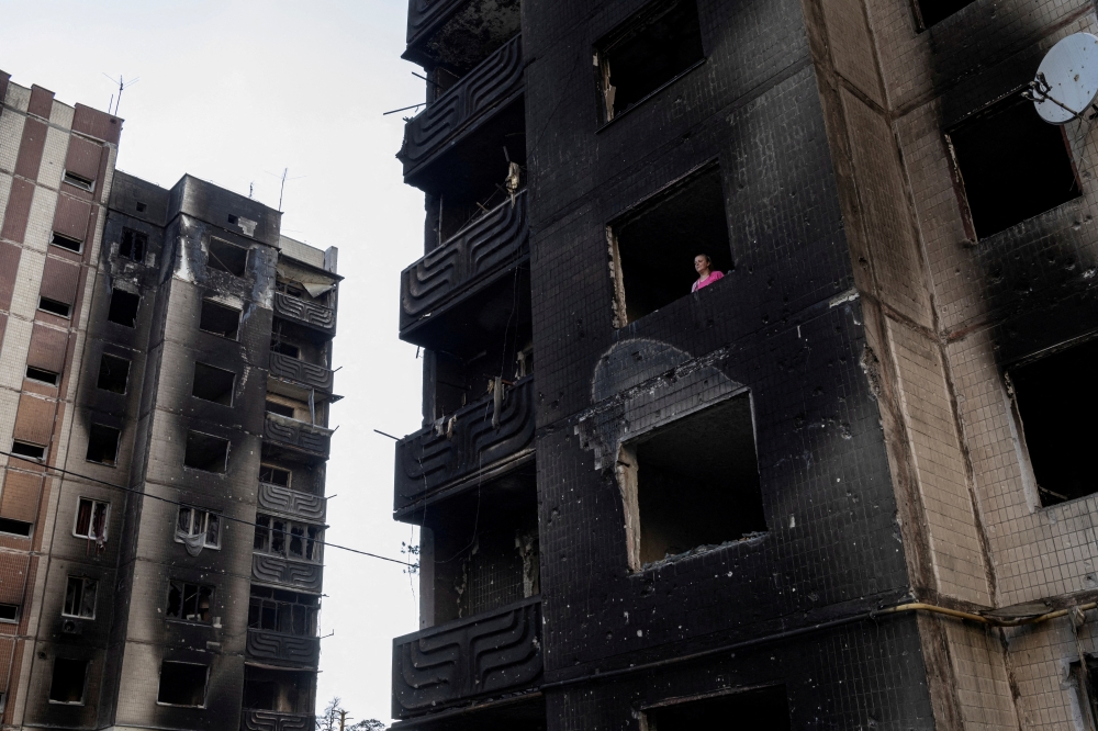 Resident Nataliia Prykhodko looks out from her burnt-out apartment in Irpin after coming back to Ukraine which she and her 17-year-old daughter left as refugees in February, outside Kyiv, as Russia's attacks on Ukraine continues, June 9, 2022. REUTERS/Marko Djurica 