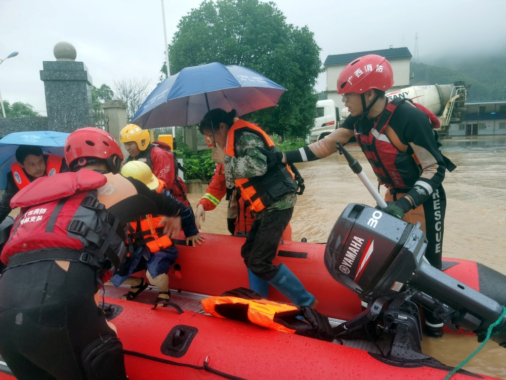Rescue workers evacuate flood-affected residents with a dinghy following heavy rainfall in Yongfu county of Guilin, Guangxi Zhuang Autonomous Region, China June 17, 2022. cnsphoto via Reuters