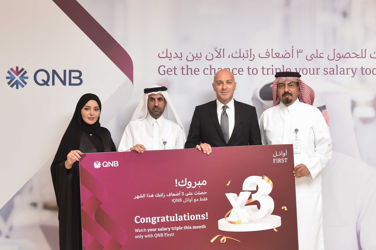 QNB officials pose for a group photo with the winner the ‘Triple your Salary’ campaign.