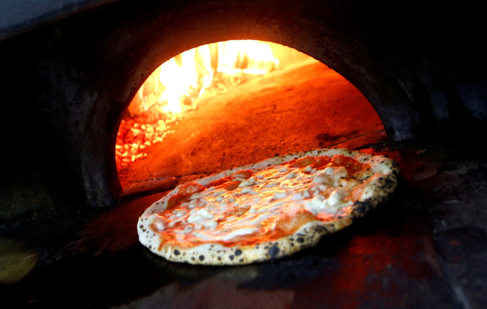 Pizza Margherita is prepared in a wood-fired oven at L'Antica Pizzeria da Michele in Naples, Italy. Reuters/Ciro De Luca/File Photo