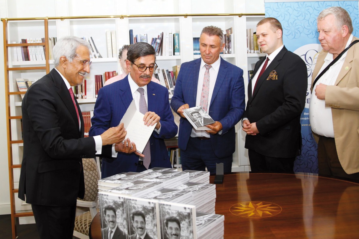 Minister of State, President of QNL H E Dr. Hamad bin Abdulaziz Al Kawari during the signing of the book.