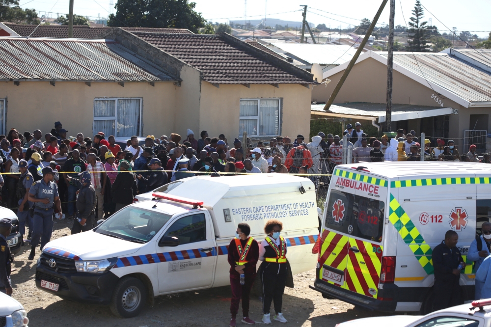 Crowd gathers as forensic personnel investigate after the deaths of patrons found inside the Enyobeni Tavern, in Scenery Park, outside East London in the Eastern Cape province, South Africa, June 26, 2022. (Reuters)