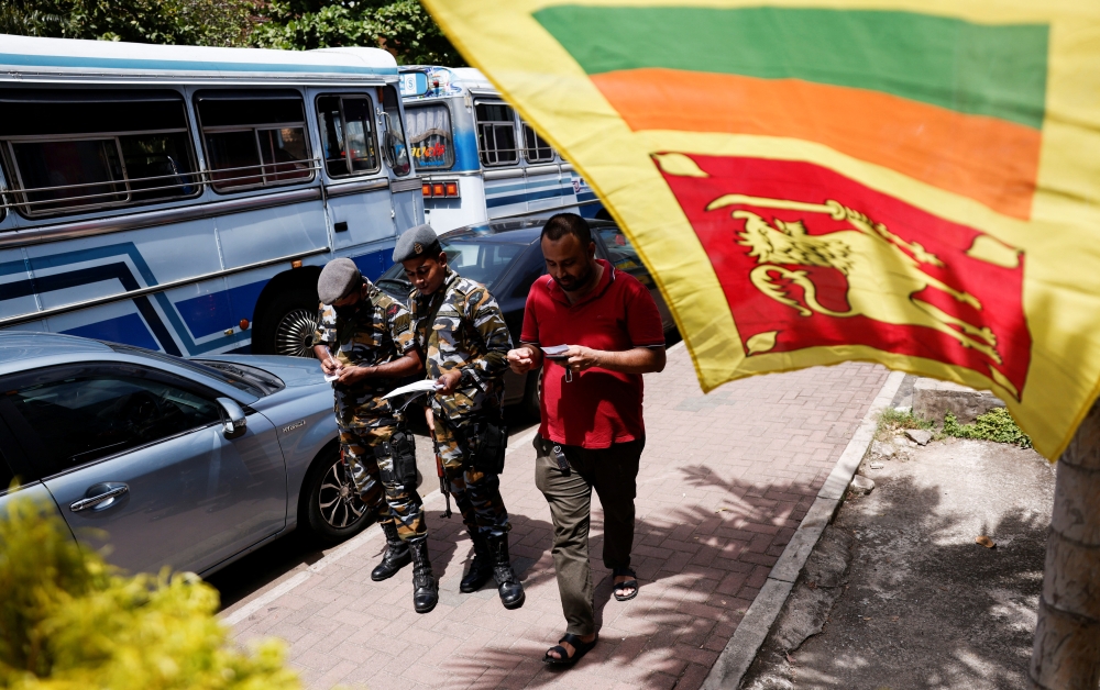 Sri Lanka's Air Force members distribute tokens to people queueing for fuel amid the country's economic crisis, in Colombo, Sri Lanka, on June 27, 2022. (Reuters/Dinuka Liyanawatte)