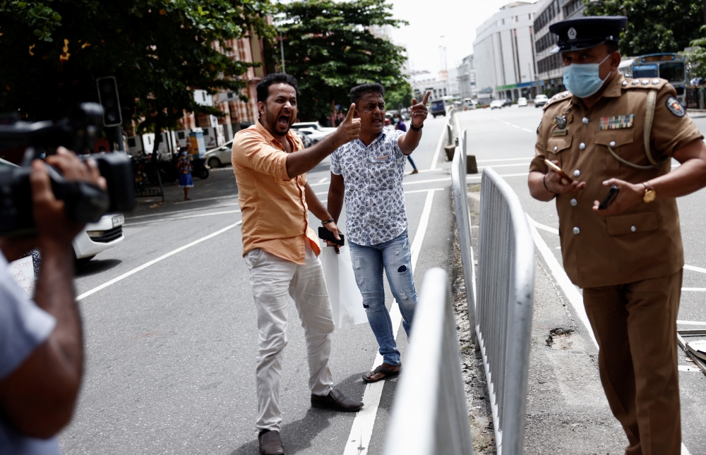 Demonstrators who blocked a main road with their vehicle to demand fuel near President Gotabaya Rajapaksa's residence, argue with a police officer in Colombo, Sri Lanka, June 29, 2022. Reuters/Dinuka Liyanawatte