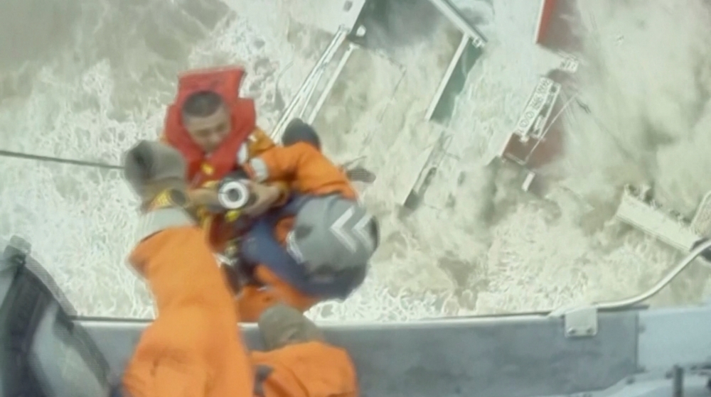 Rescuers lift a crew member of a sinking vessel into a helicopter, after it snapped in two as tropical storm Chaba passed through, according to authorities, in waters off Hong Kong, China in this screen grab taken from a video July 2, 2022. Hong Kong Government Flying Service/Handout via REUTERS
