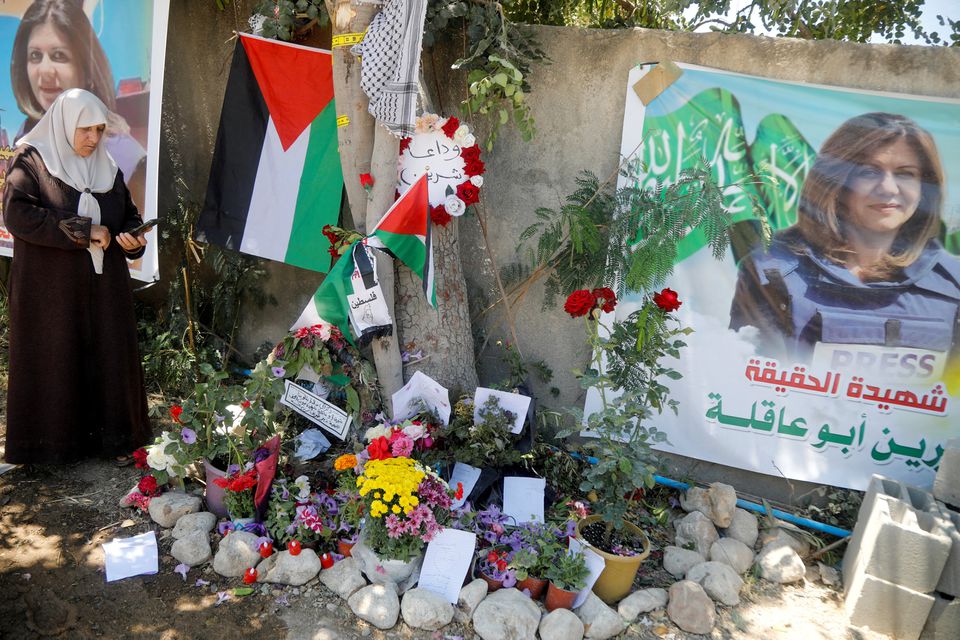 A Palestinian woman takes pictures at the scene where Al Jazeera reporter Shireen Abu Akleh was shot dead during an Israeli raid, in Jenin, in the Israeli-occupied West Bank, May 17, 2022. REUTERS/Raneen Sawafta

