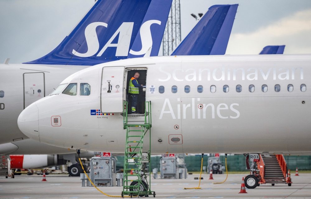 A technician works aboard a SAS Airbus A320neo at Kastrup Airport after pilots of Scandinavian Airlines went on strike, in Kastrup, Denmark, July 4, 2022. (Reuters)

