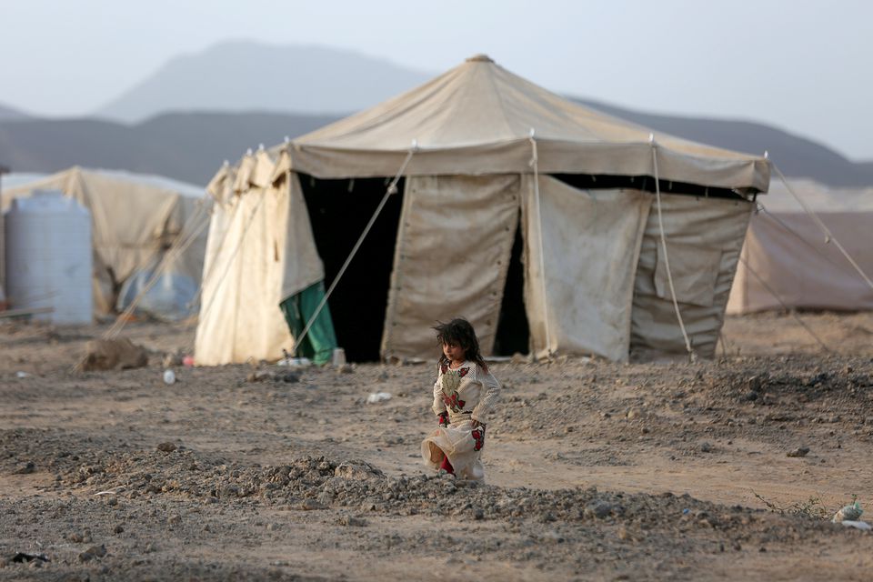 A girl walks past a tent at a camp for internally displaced people in Marib, Yemen, April 5, 2021. (Reuters/Ali Owidha)