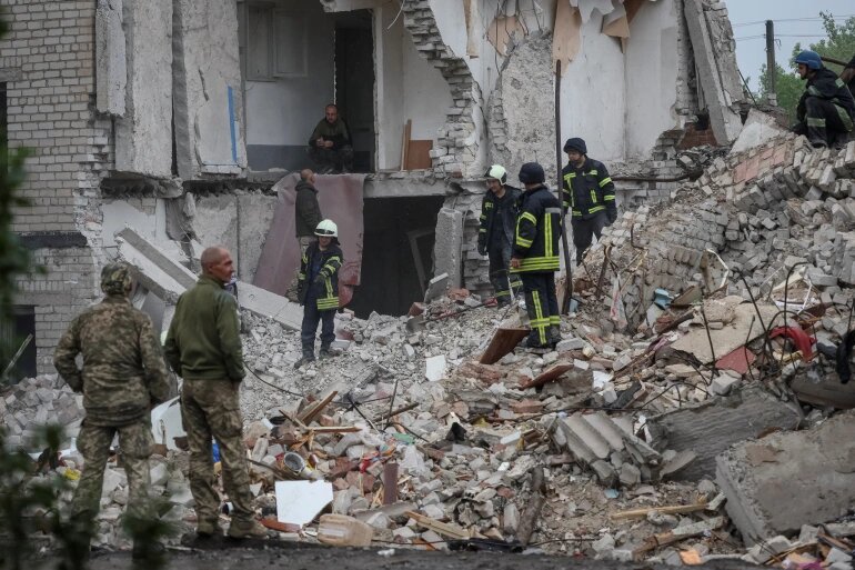 Rescuers work at a residential building damaged by a Russian military raid in the town of Chasiv Yar [Gleb Garanich/Reuters]