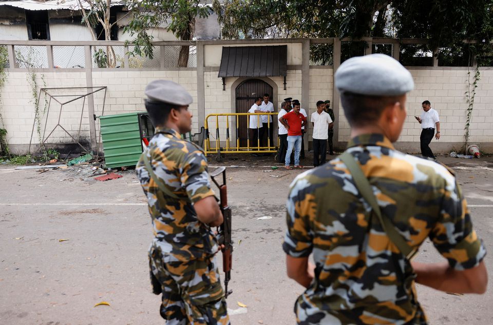 People stand next to the private residence of Prime Minister Ranil Wickremesinghe, after demonstrators burnt it during a protest against him, amid the country's economic crisis, in Colombo, Sri Lanka July 10, 2022. REUTERS/Dinuka Liyanawatte


